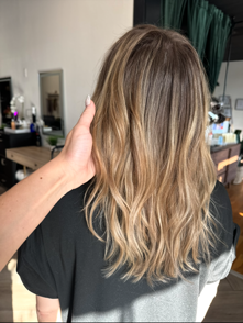 A person is touching a woman 's hair in a room