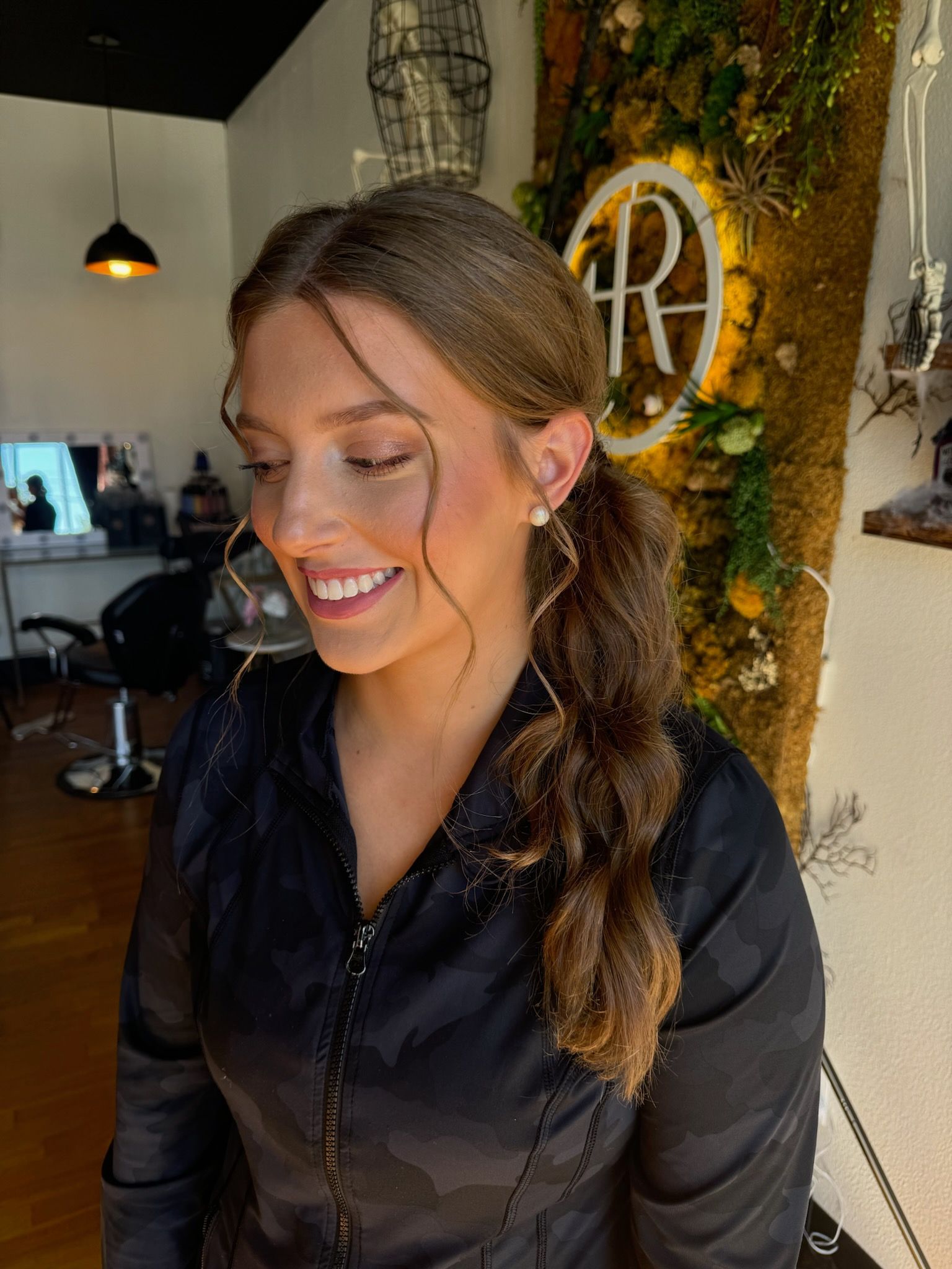 A woman is smiling in front of a sign that says r on it