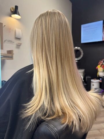Blond hair with highlights; woman in a salon chair.