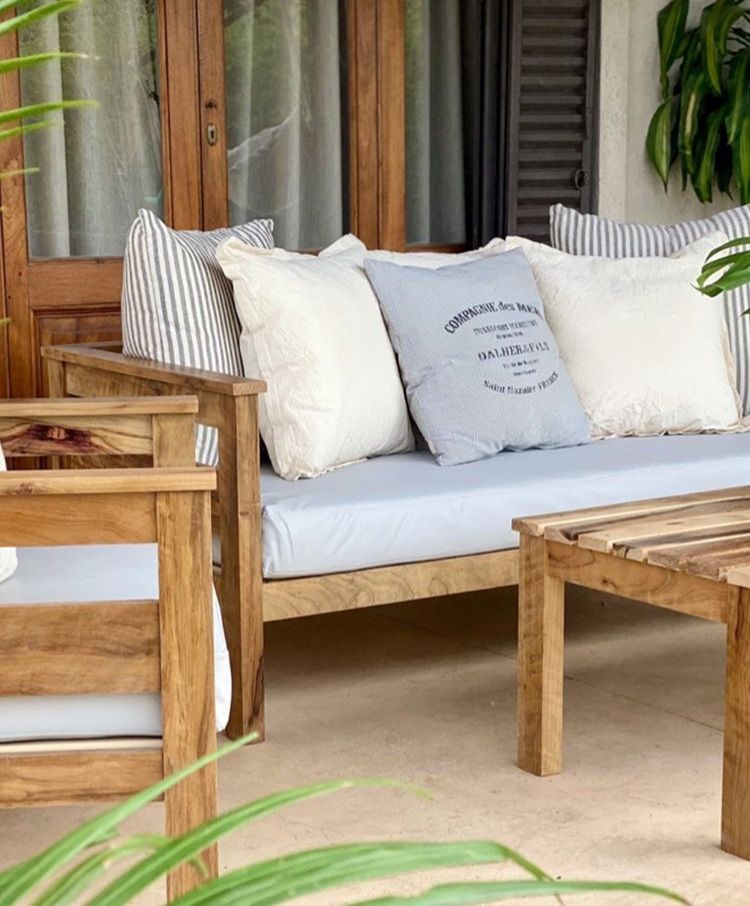 Asientos de madera al aire libre con cojines en un patio.