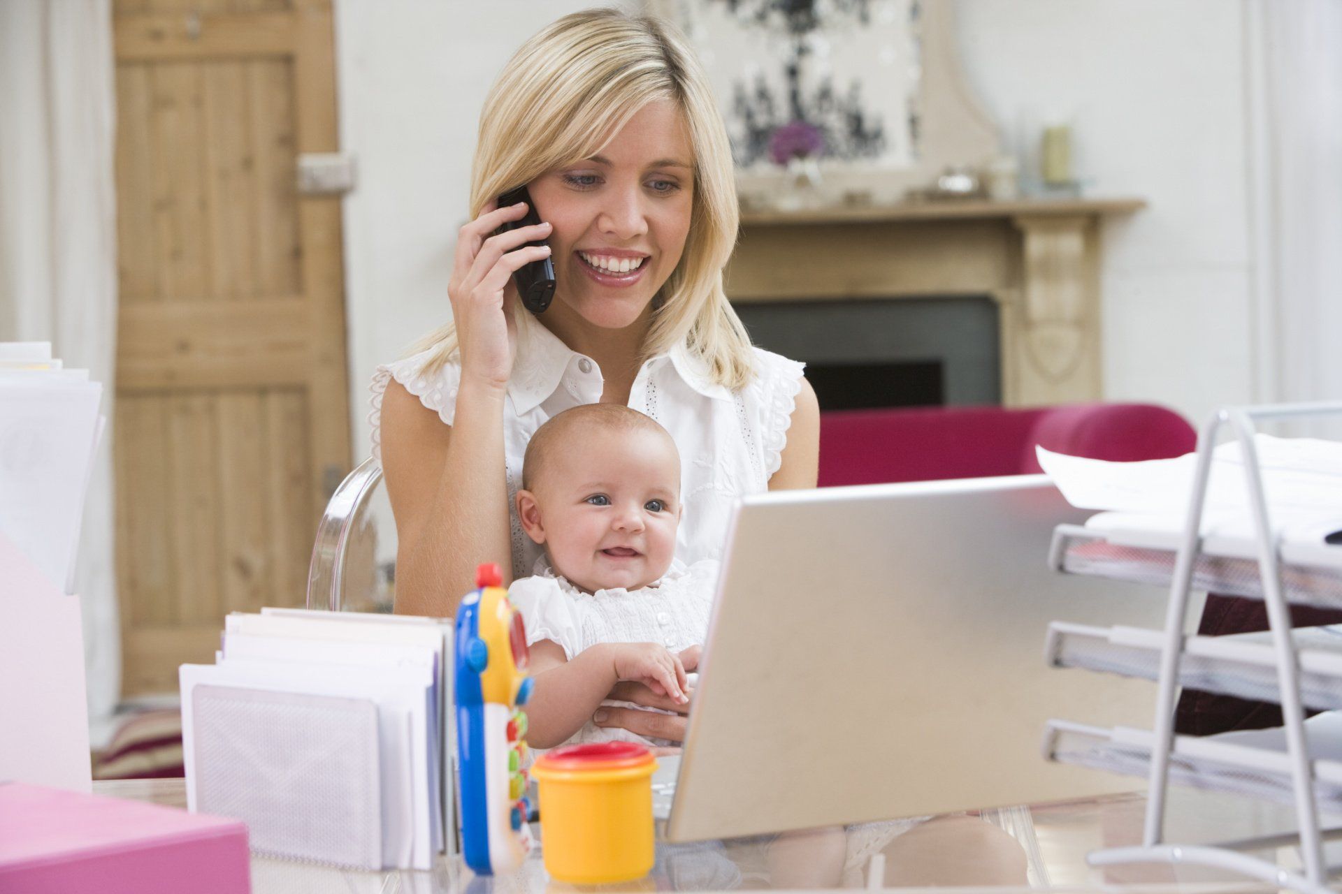 mom and baby looking at computer while mom talks on the phone