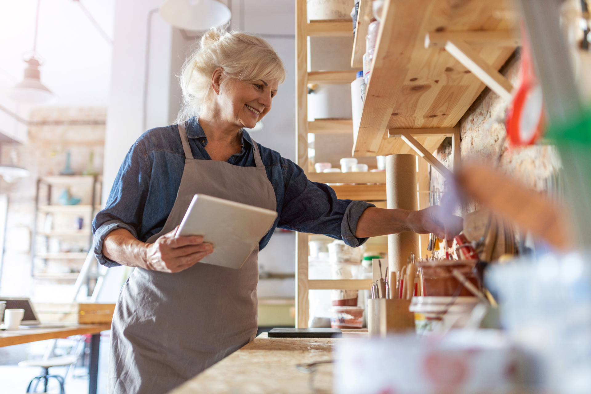 Person working in art studio holding smart tablet