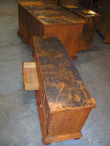 A wooden chest with a drawer open is sitting on a concrete floor.