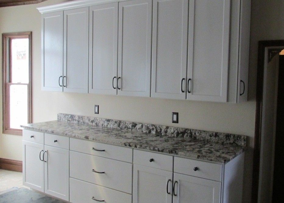 A kitchen with white cabinets and granite counter tops