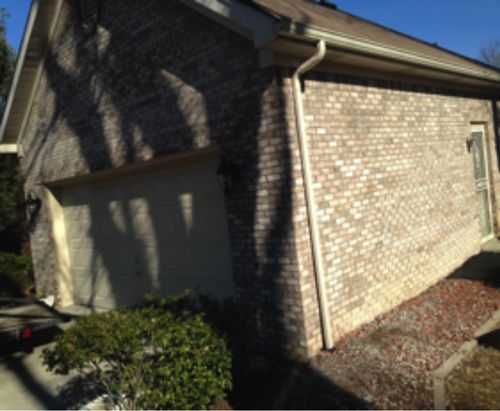A brick house with a garage and a gutter