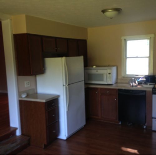 A kitchen with a white refrigerator and a microwave