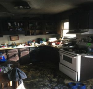 A kitchen with black cabinets and a white stove