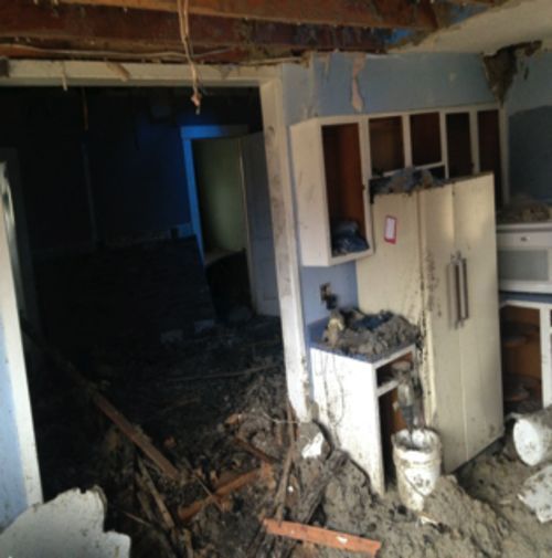 A messy kitchen with a refrigerator