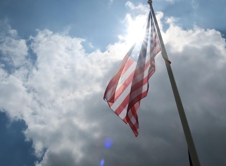 Patriotic flag backlit by sun and clouds, funeral homes Phoenix, AZ tribute