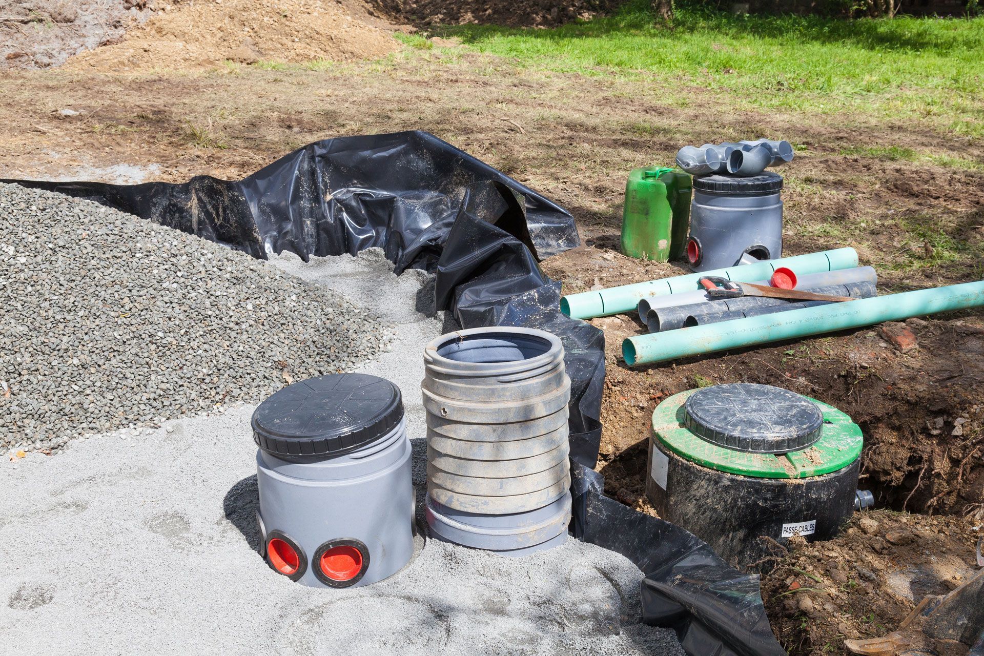 Gravel, pipes, and septic system components on a construction site.
