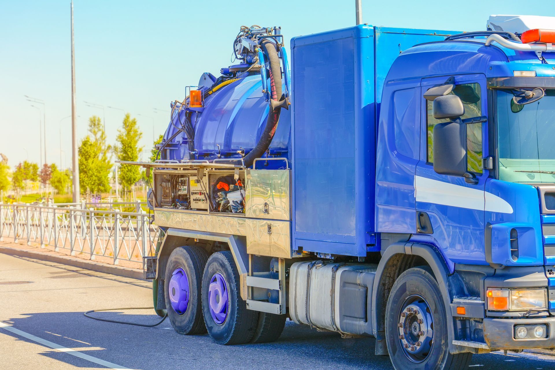 Blue septic truck on road.