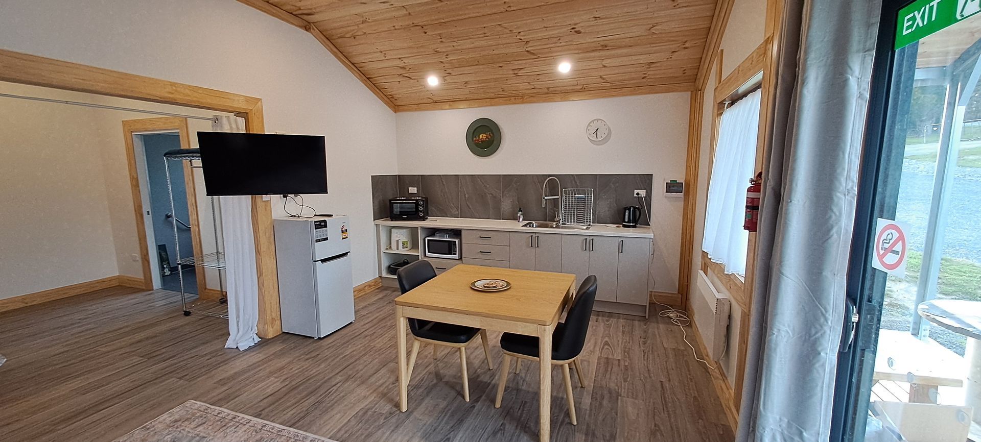 A living room with a table and chairs and a flat screen tv.