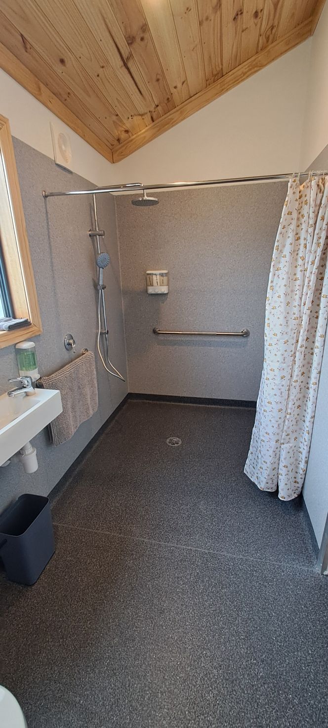 A bathroom with a walk in shower and a sink.