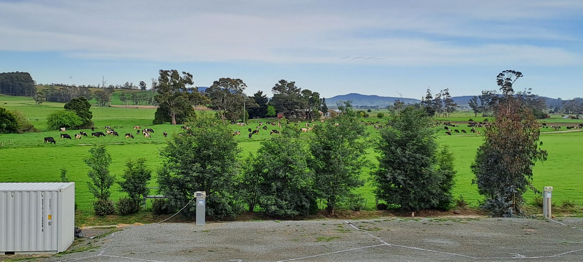 A group of caravans are parked in a grassy field at sunset.