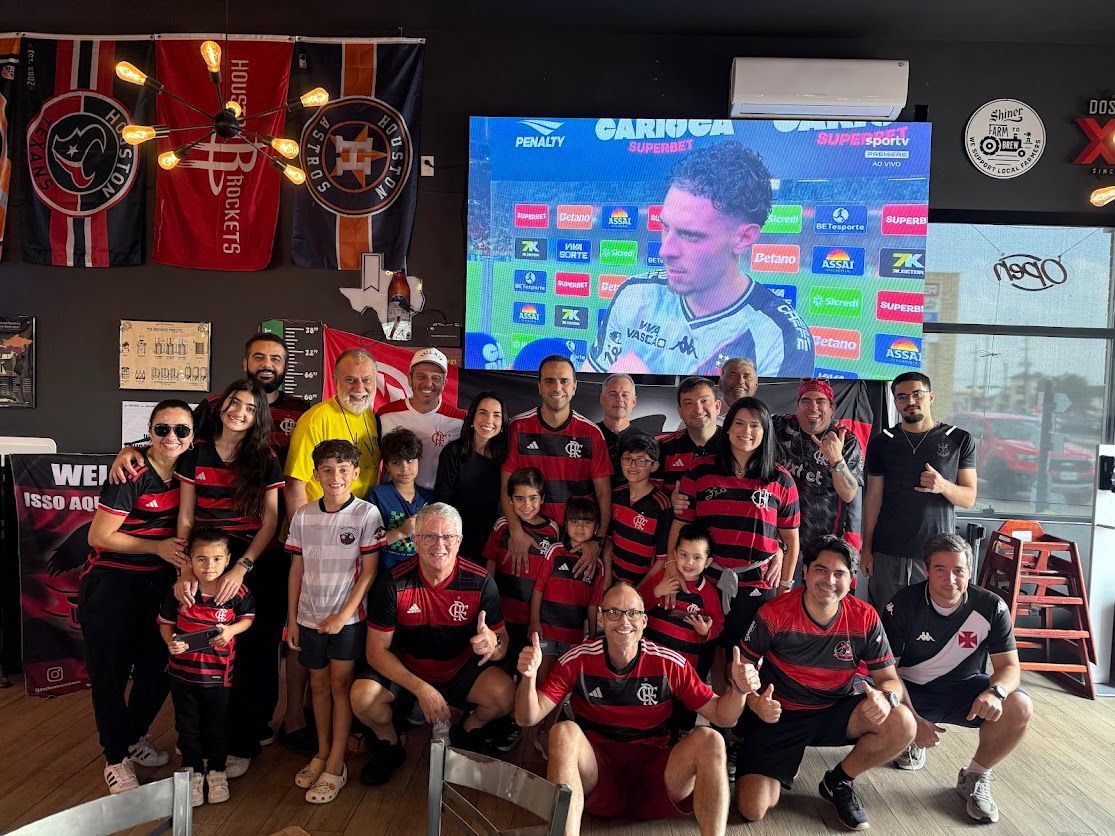 A group of people are posing for a picture in front of a large screen.