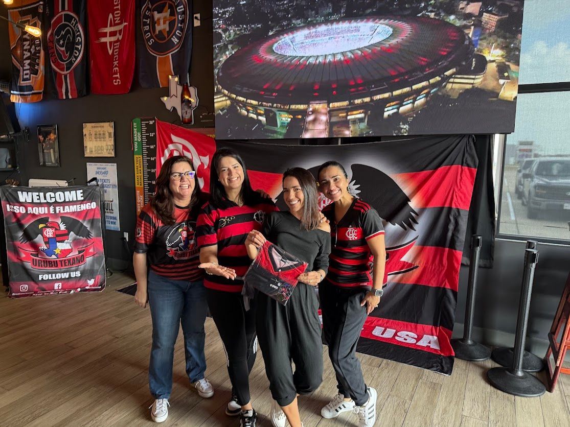 A group of women are posing for a picture in front of a large screen.