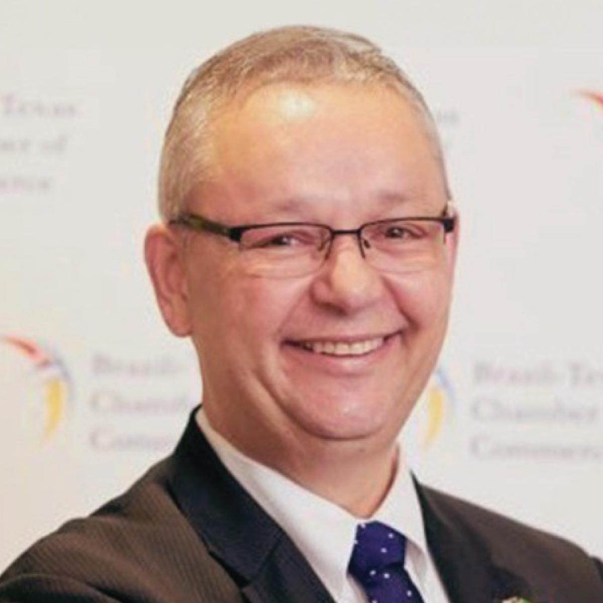 A man in a suit and tie is smiling for the camera.