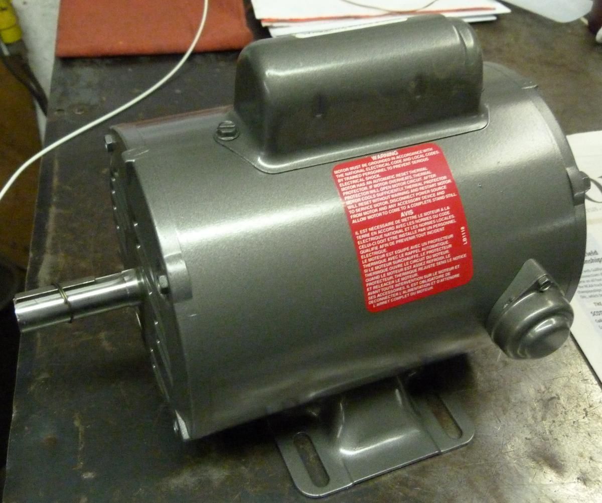 A gray motor with a red warning label on it