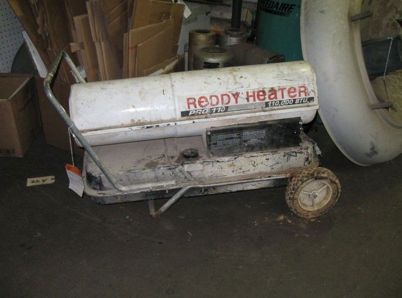 A ready heater is sitting on the floor in a garage