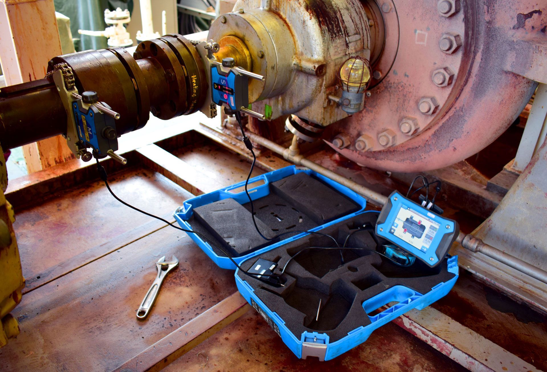 A blue case is sitting on a table next to a machine.
