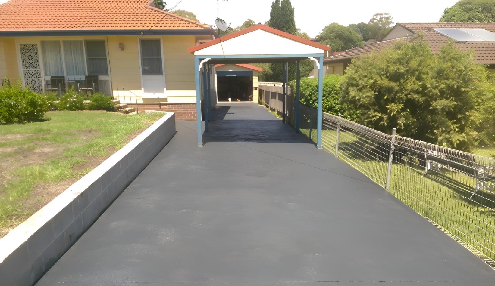 A Driveway Leading To A House With A Carport — Concept Concreting NSW In Figtree, NSW