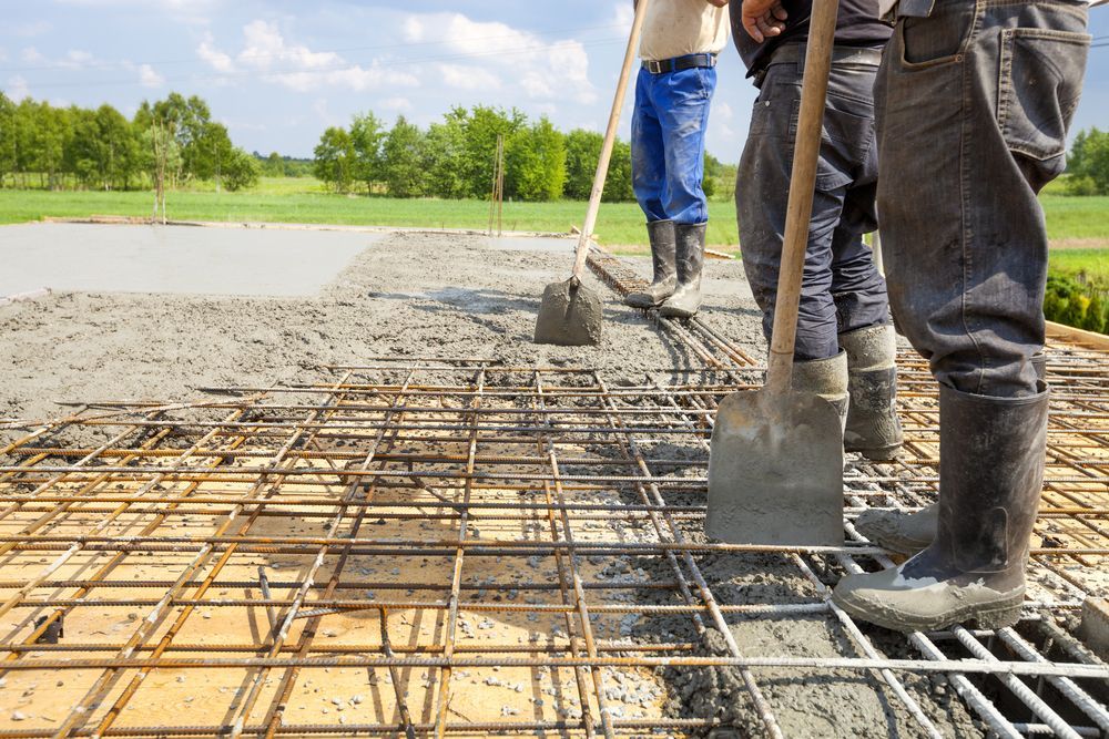 A Group Of Construction Workers Are Working On A Concrete Floor — Concept Concreting NSW In Figtree, NSW