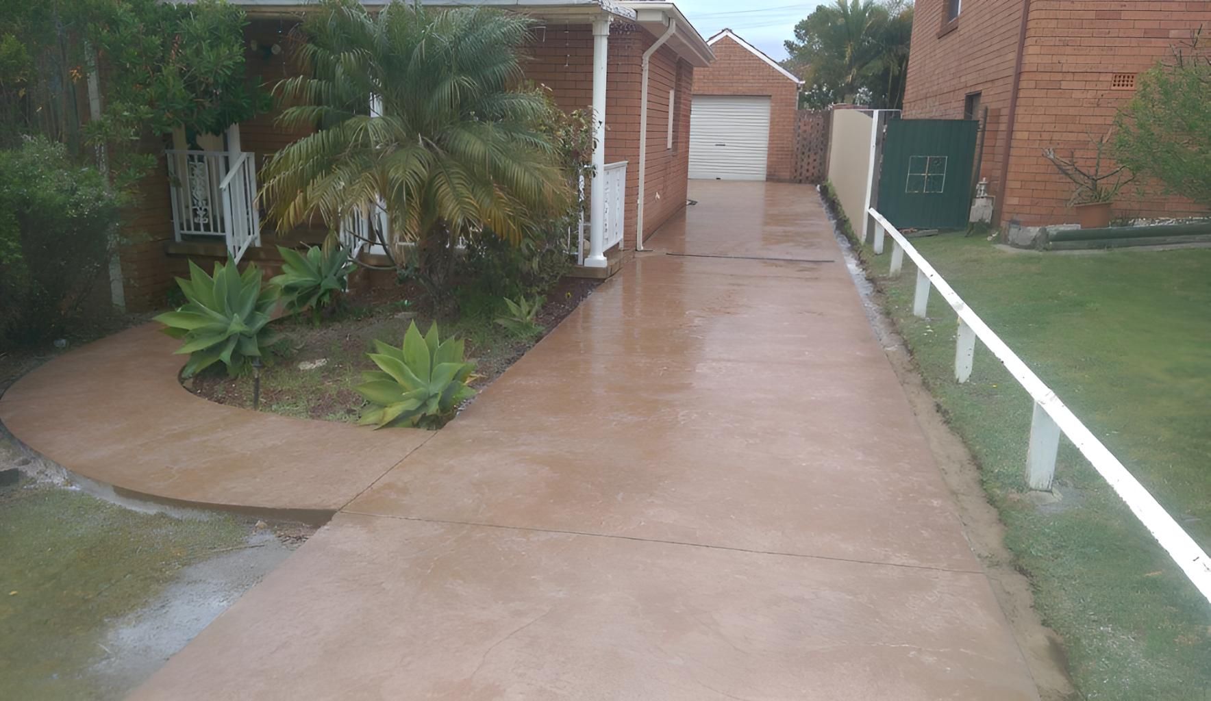 A Concrete Driveway Leading To A House — Concept Concreting NSW In Thirroul, NSW