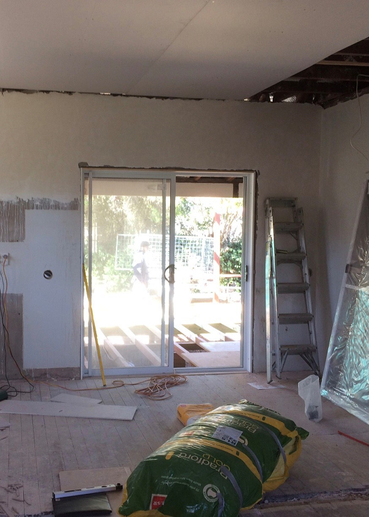 A bag of insulation sits on the floor in a room under construction — Hunter Kitchen King In Rutherford, NSW