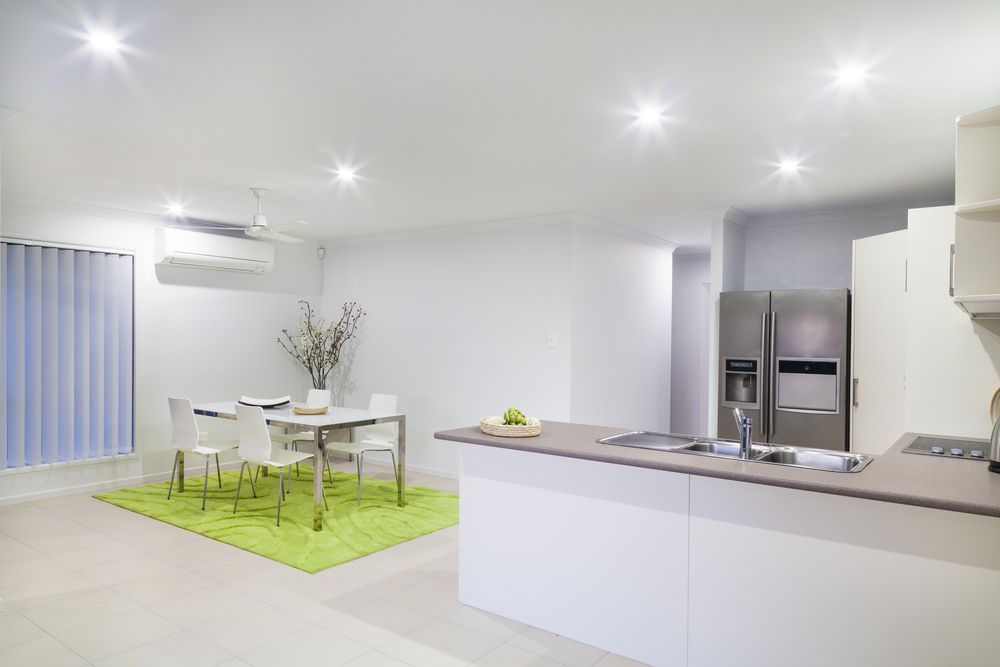 A Kitchen With a Table and Chairs and a Refrigerator — Hunter Kitchen King In Maitland, NSW