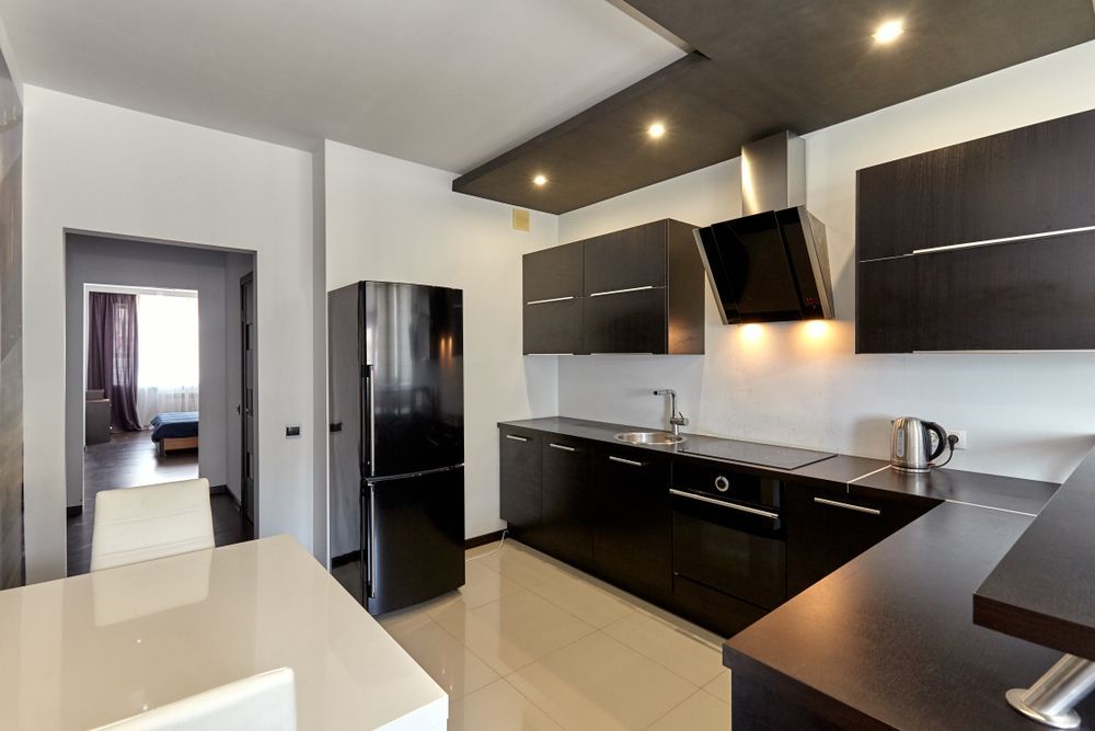 A Kitchen With Black Cabinets and a Black Refrigerator — Hunter Kitchen King In Beresfield, NSW