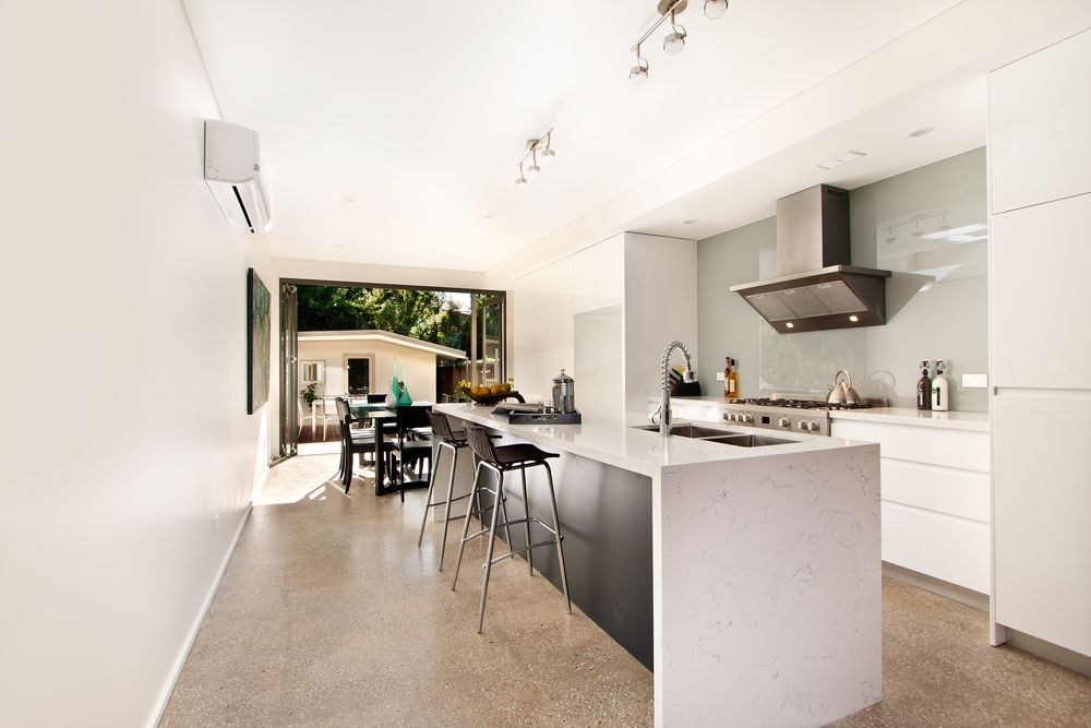 A Kitchen With White Cabinets and a Large Island in the Middle — Hunter Kitchen King In Cameron Park, NSW