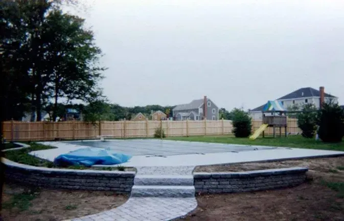 A swimming pool is being built in the backyard of a house.