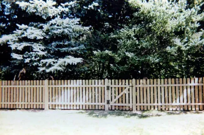 A wooden fence with trees in the background
