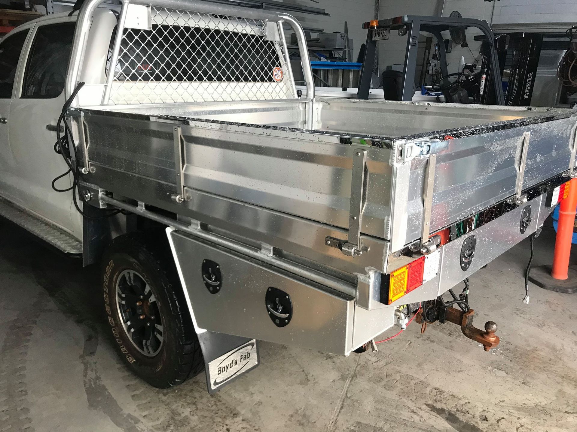White utility truck bed with metal frame, towing hitch, and black wheel — Boyd's Fabrications In Portsmith, QLD