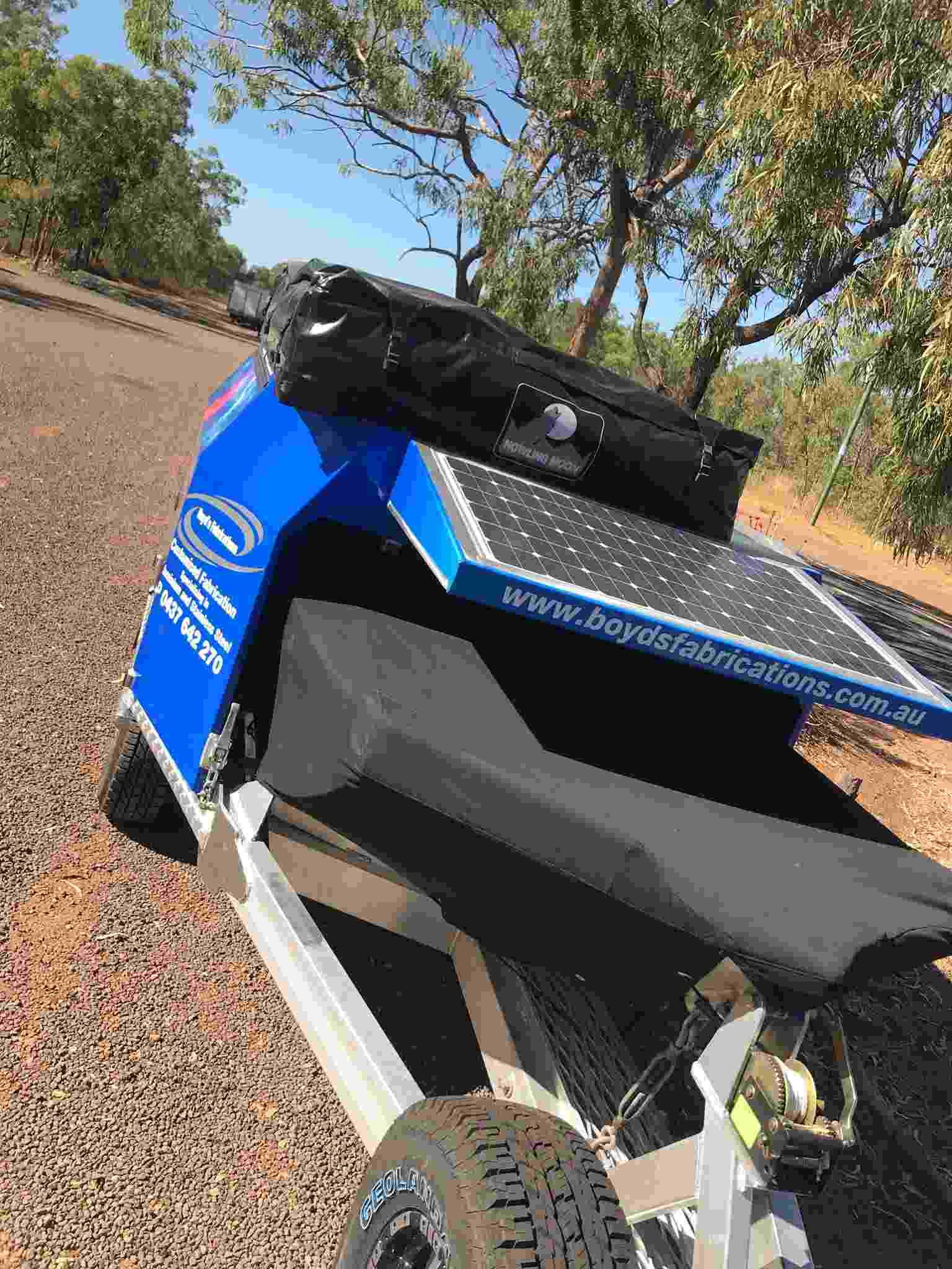 A Blue and White Motorcycle Trailer is Parked on the Side of the Road — Boyd's Fabrications In Portsmith, QLD 