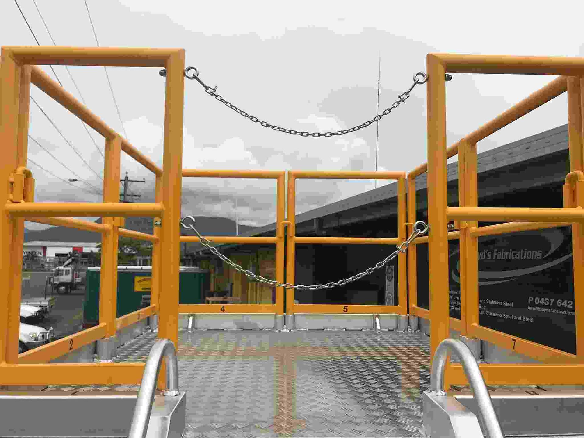 A Ladder Is Attached to A Metal Platform with A Yellow Railing — Boyd's Fabrications In Portsmith, QLD 