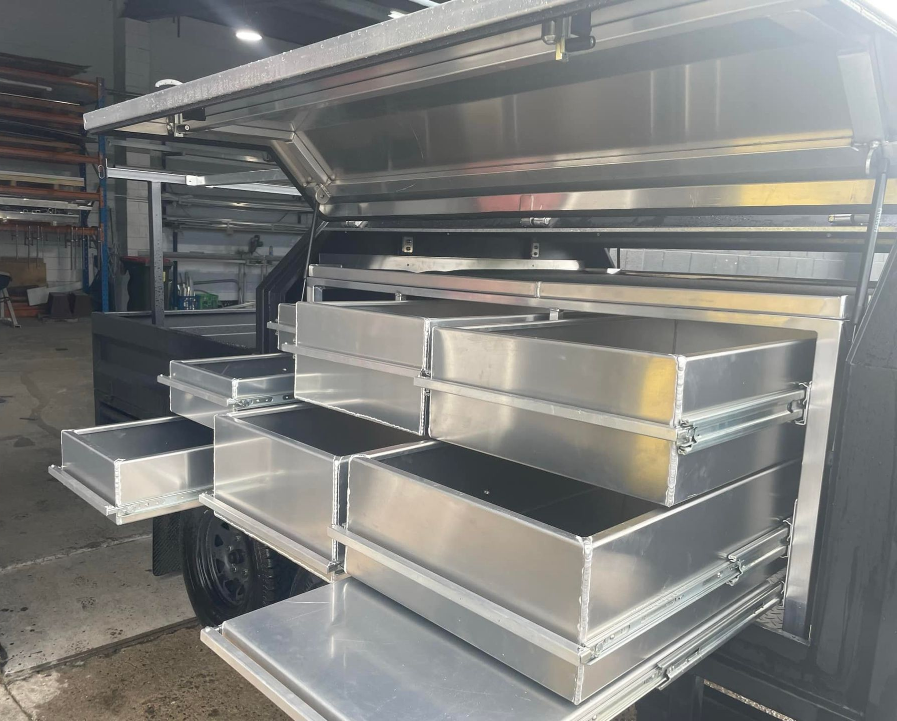 Aluminum truck bed storage system with open drawers, silver color, outdoor setting. — Boyd's Fabrications In Portsmith, QLD
