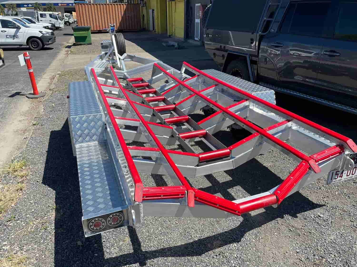 A Boat Trailer is Parked in a Gravel Lot Next to a Truck — Boyd's Fabrications In Portsmith, QLD