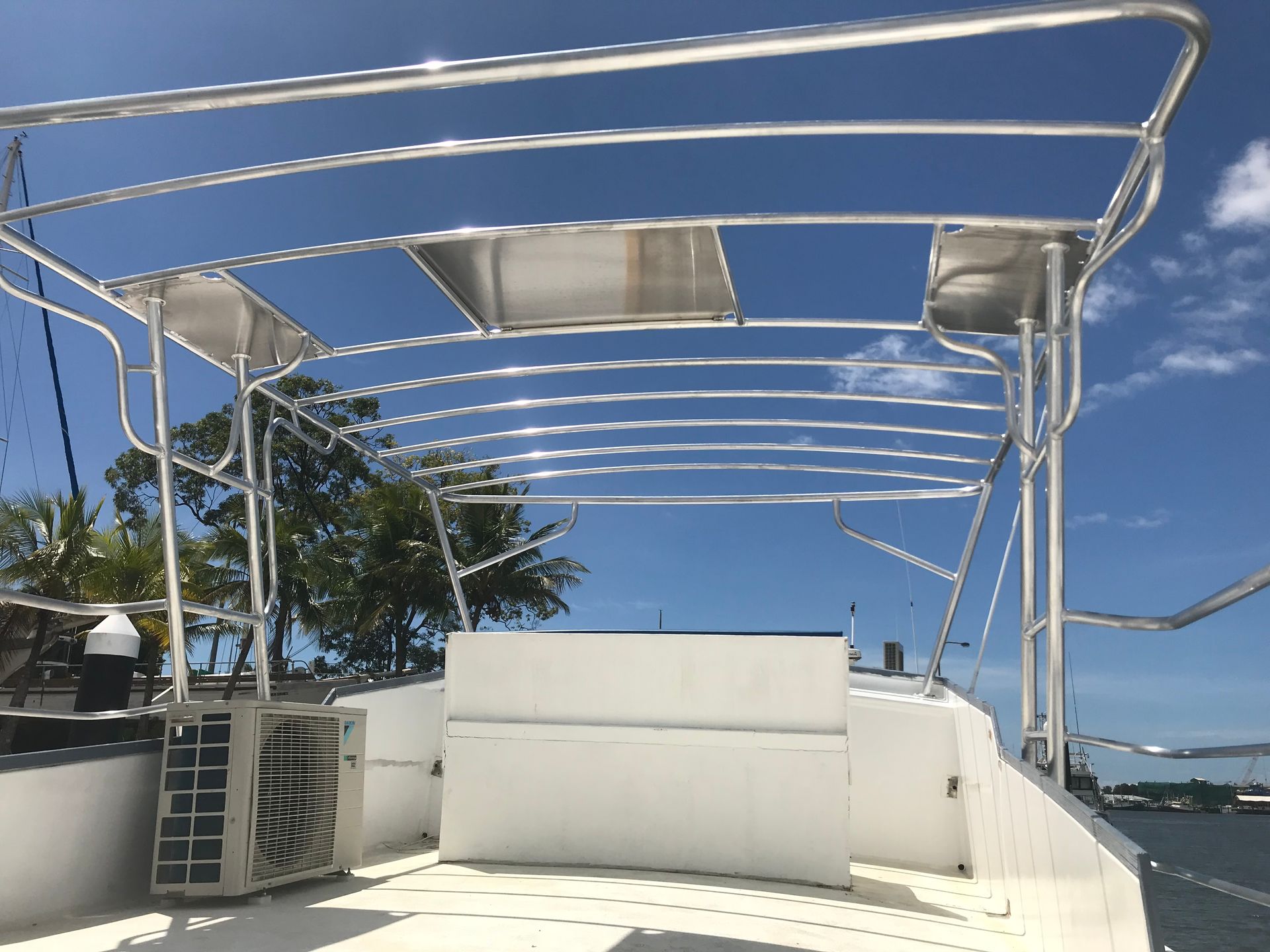 A boat deck with a silver metal frame, blue sky, and an air conditioning unit.— Boyd's Fabrications In Portsmith, QLD 