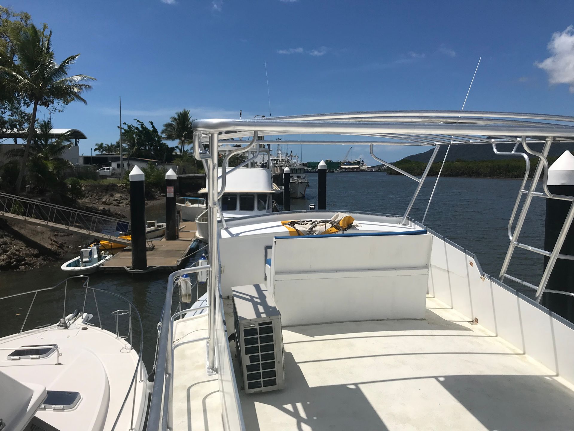A white boat docked in a marina under a clear blue sky.— Boyd's Fabrications In Portsmith, QLD 