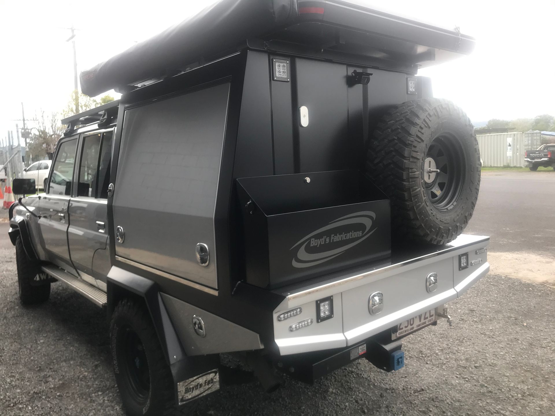 Gray 4x4 truck with a black utility box, spare tire, and awning.— Boyd's Fabrications In Portsmith, QLD 