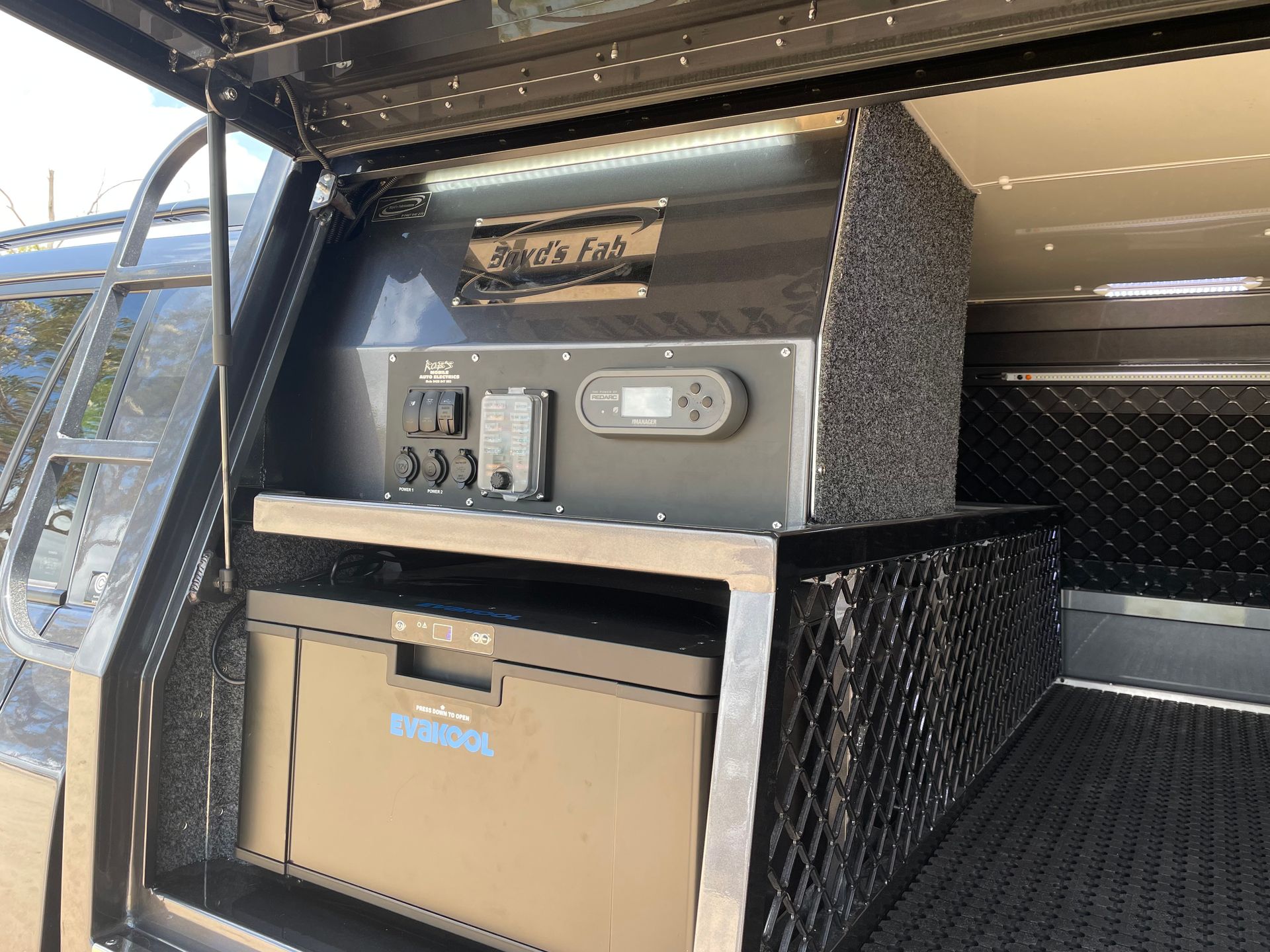 A black truck bed storage system with a refrigerator and control panel. — Boyd's Fabrications In Portsmith, QLD 