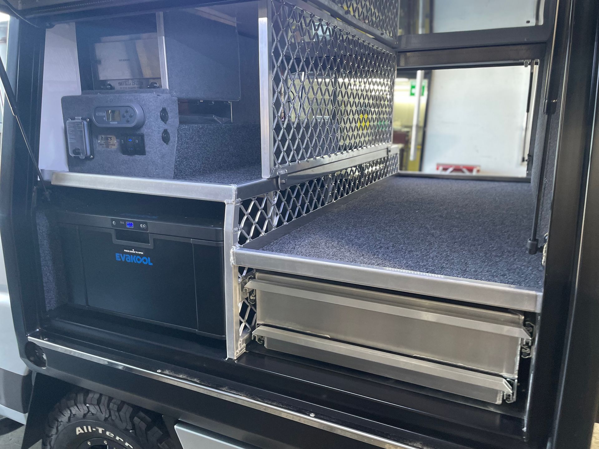 A truck bed storage system with a drawer, fridge, and open compartments; black and silver.— Boyd's Fabrications In Portsmith, QLD 