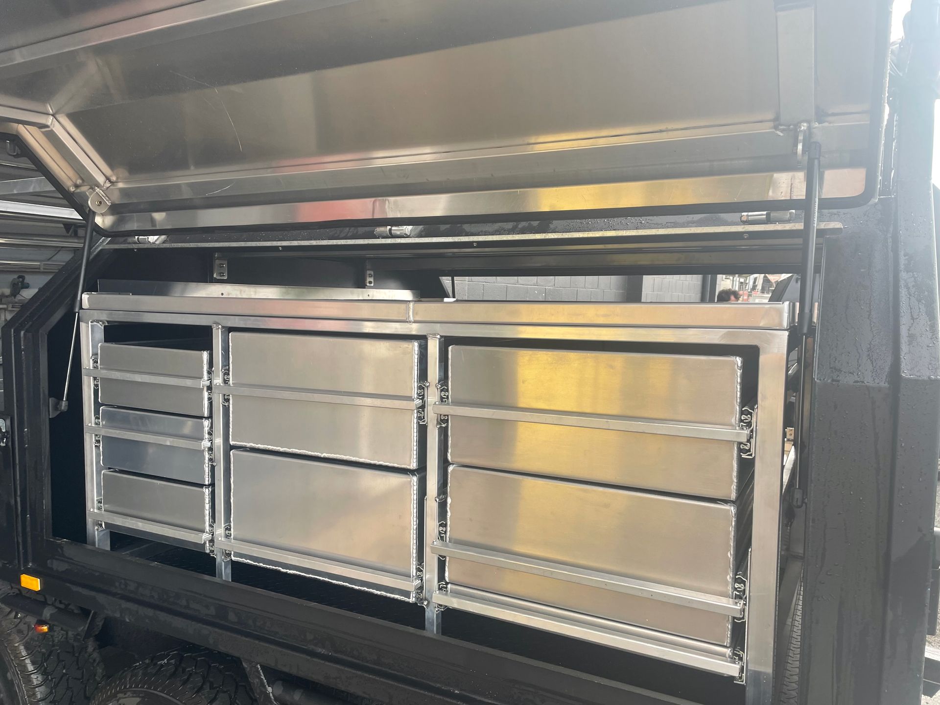 Stainless steel drawers built into the side of a black truck bed, under a canopy.— Boyd's Fabrications In Portsmith, QLD 