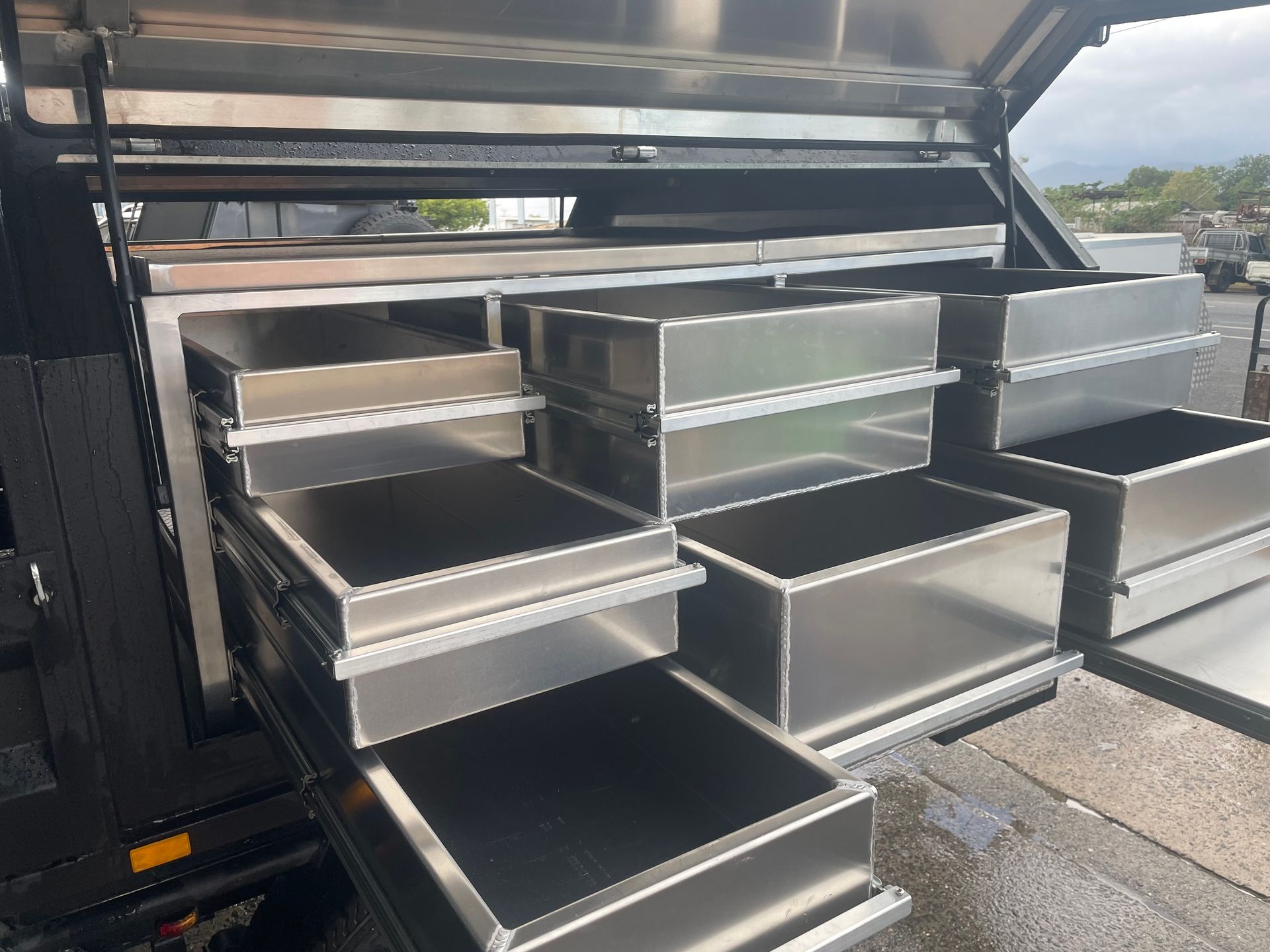 Stainless steel truck bed storage drawers, open, in an outdoor setting.— Boyd's Fabrications In Portsmith, QLD 
