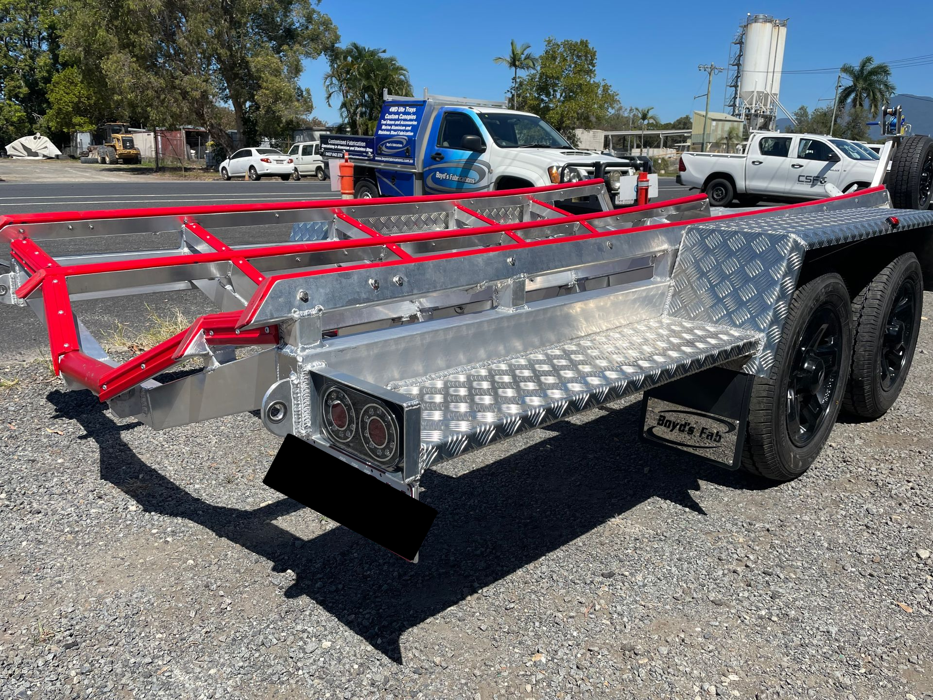 Aluminum trailer with red railing and black wheels, parked outdoors. — Boyd's Fabrications In Portsmith, QLD
