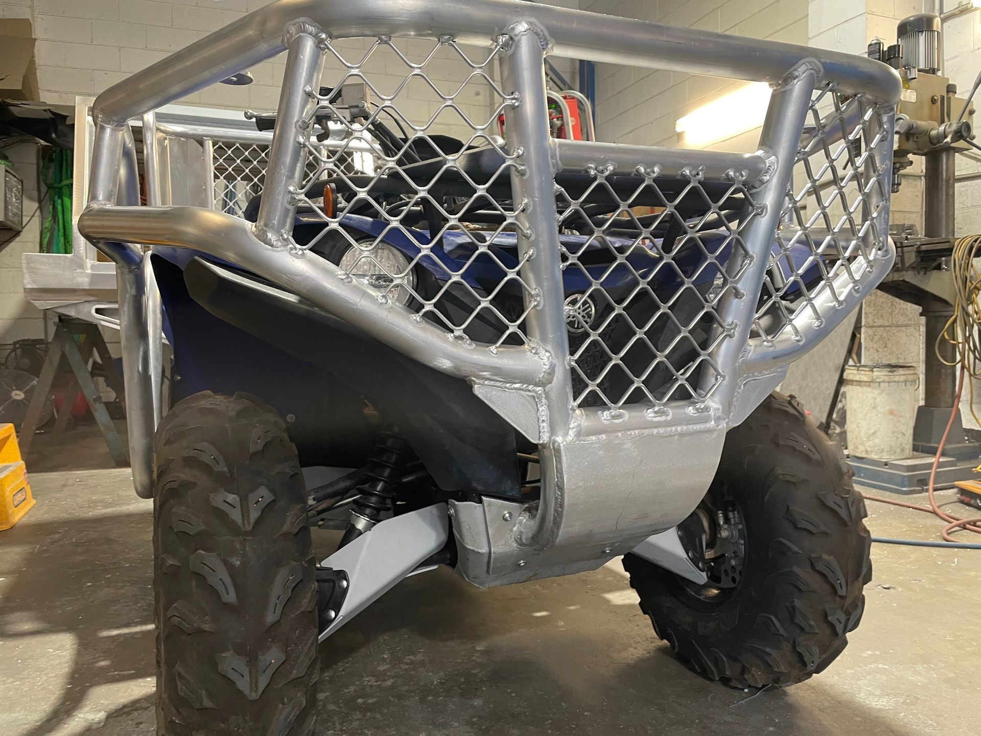 Blue ATV with silver roll cage and large tires, in a workshop.— Boyd's Fabrications In Portsmith, QLD 