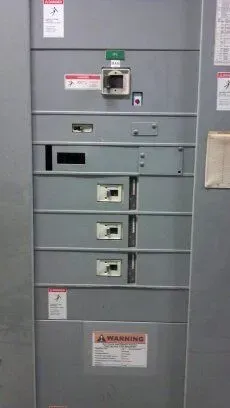 A close up of a electrical panel with a warning sign on it.