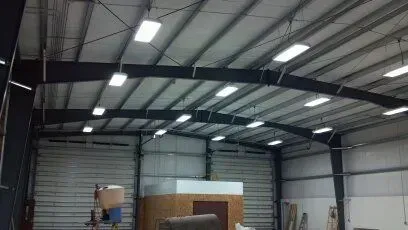 A large warehouse with a lot of lights hanging from the ceiling.