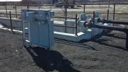 A fenced in area with a lot of pipes and electrical equipment.